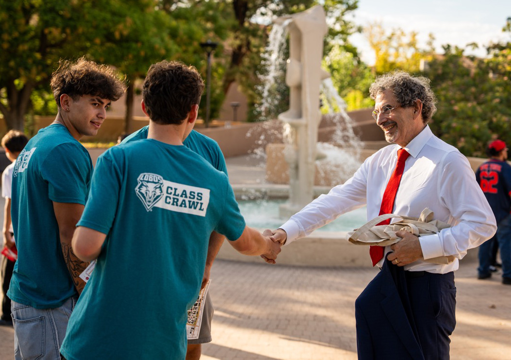 president goldstein shaking a student's hand